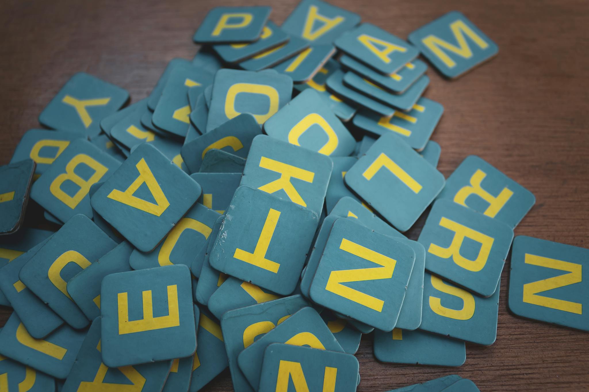 Our Mission 2 A collection of vintage wooden letter tiles scattered over a rustic wooden surface, perfect for design concepts.