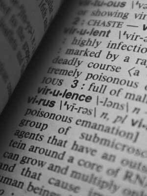 Black and white close-up of a dictionary page showing the definition of 'virus.'