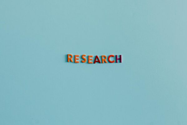 Colorful uppercase letters spelling 'RESEARCH' on a soft blue background. Ideal for education and science topics.